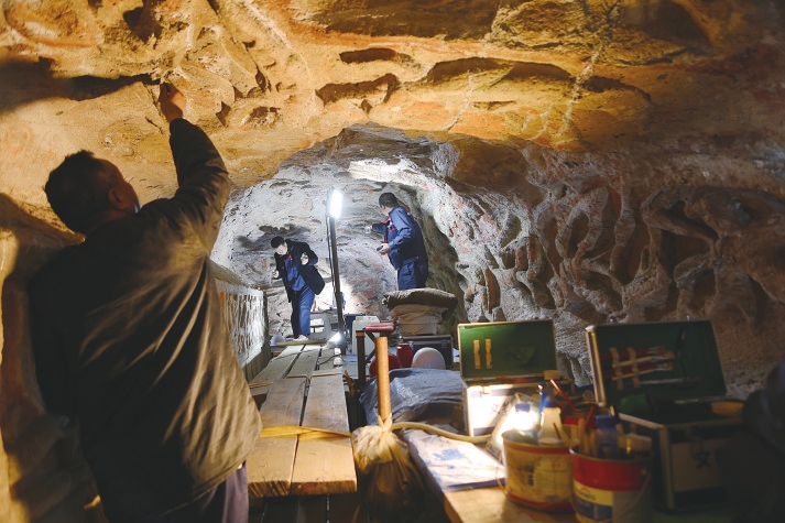 文物修復人員對石窟頂部進行修復。