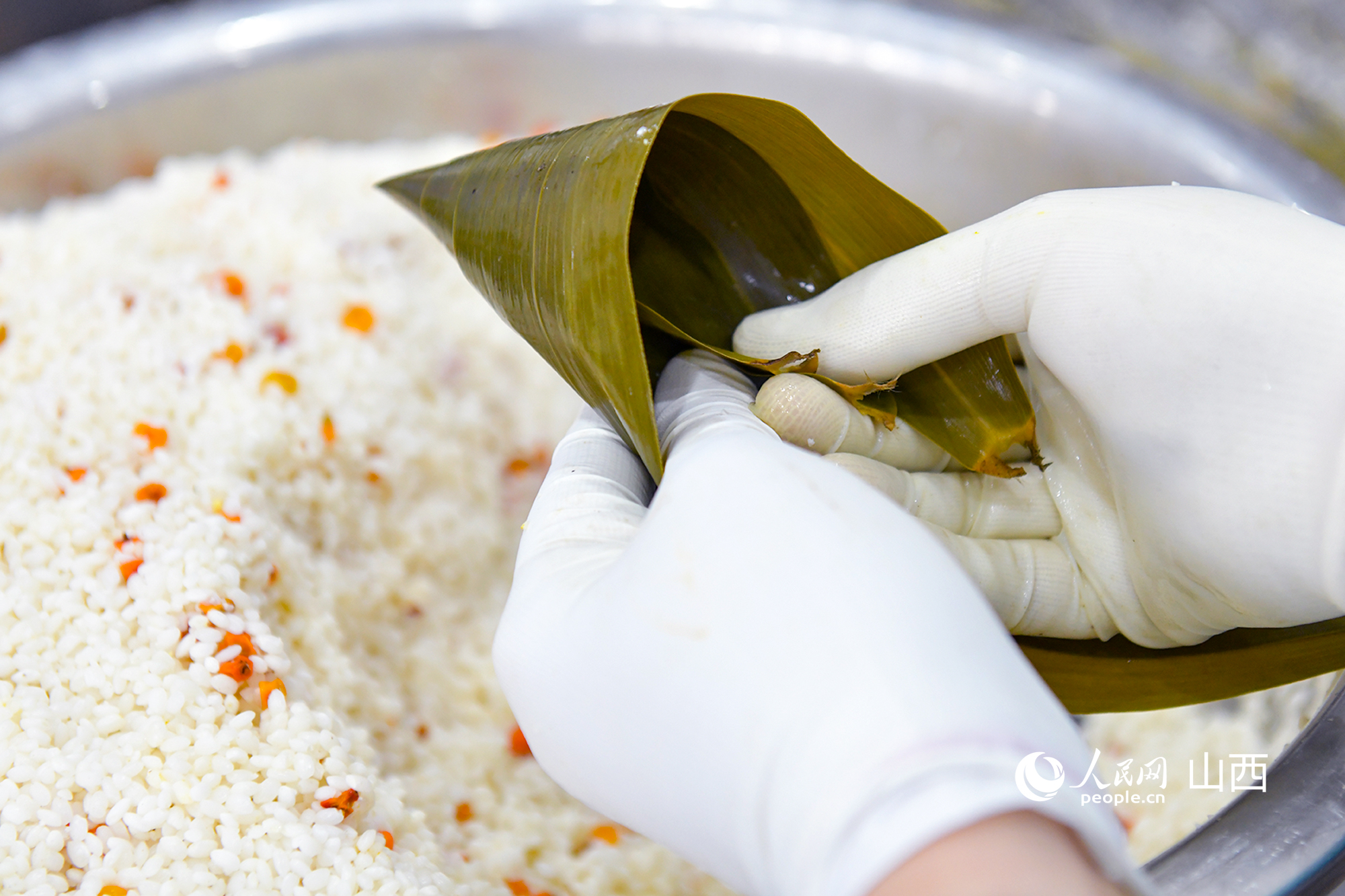 村民正在包制粽子。