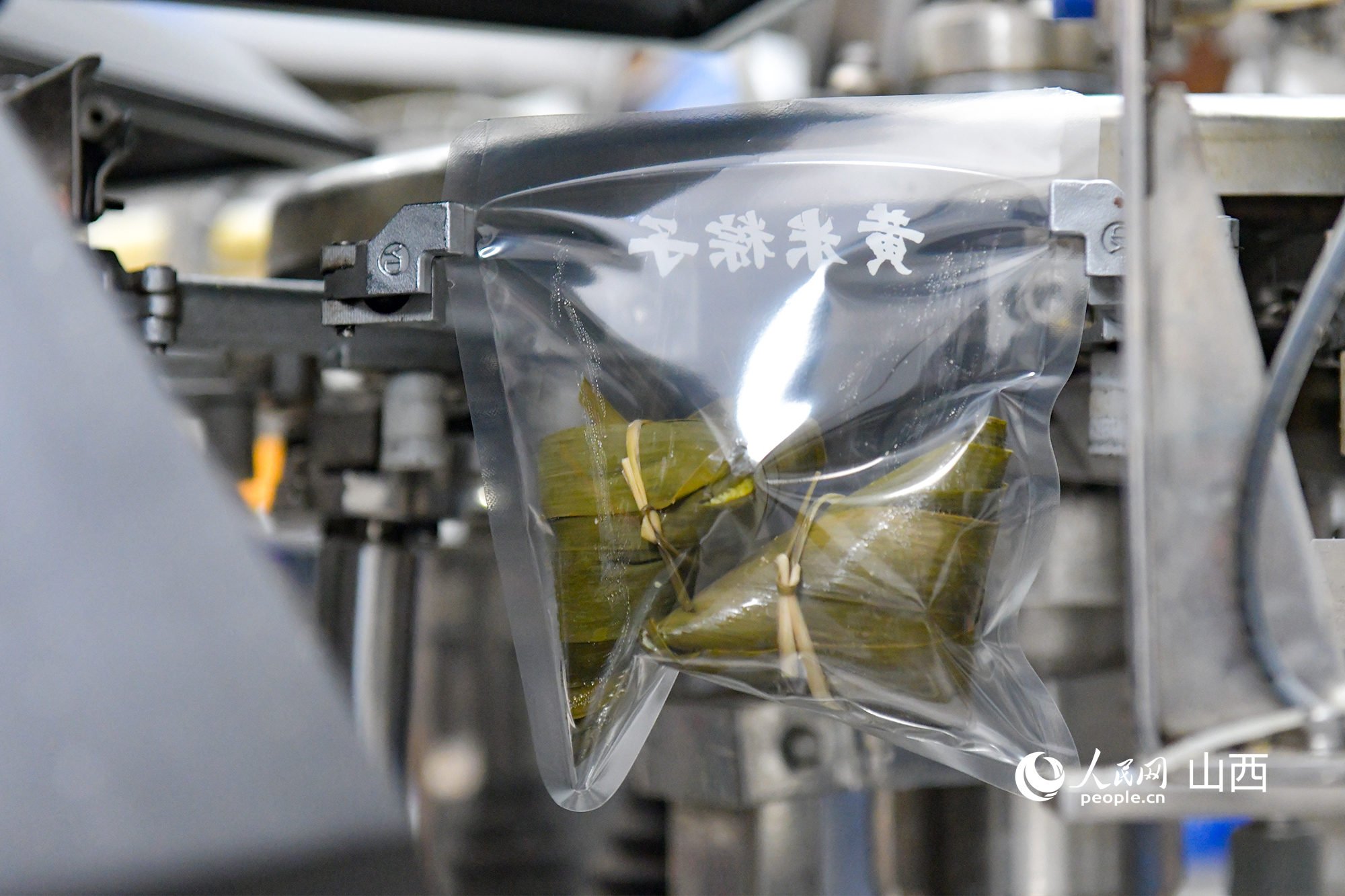 粽子蒸煮后進行真空包裝。