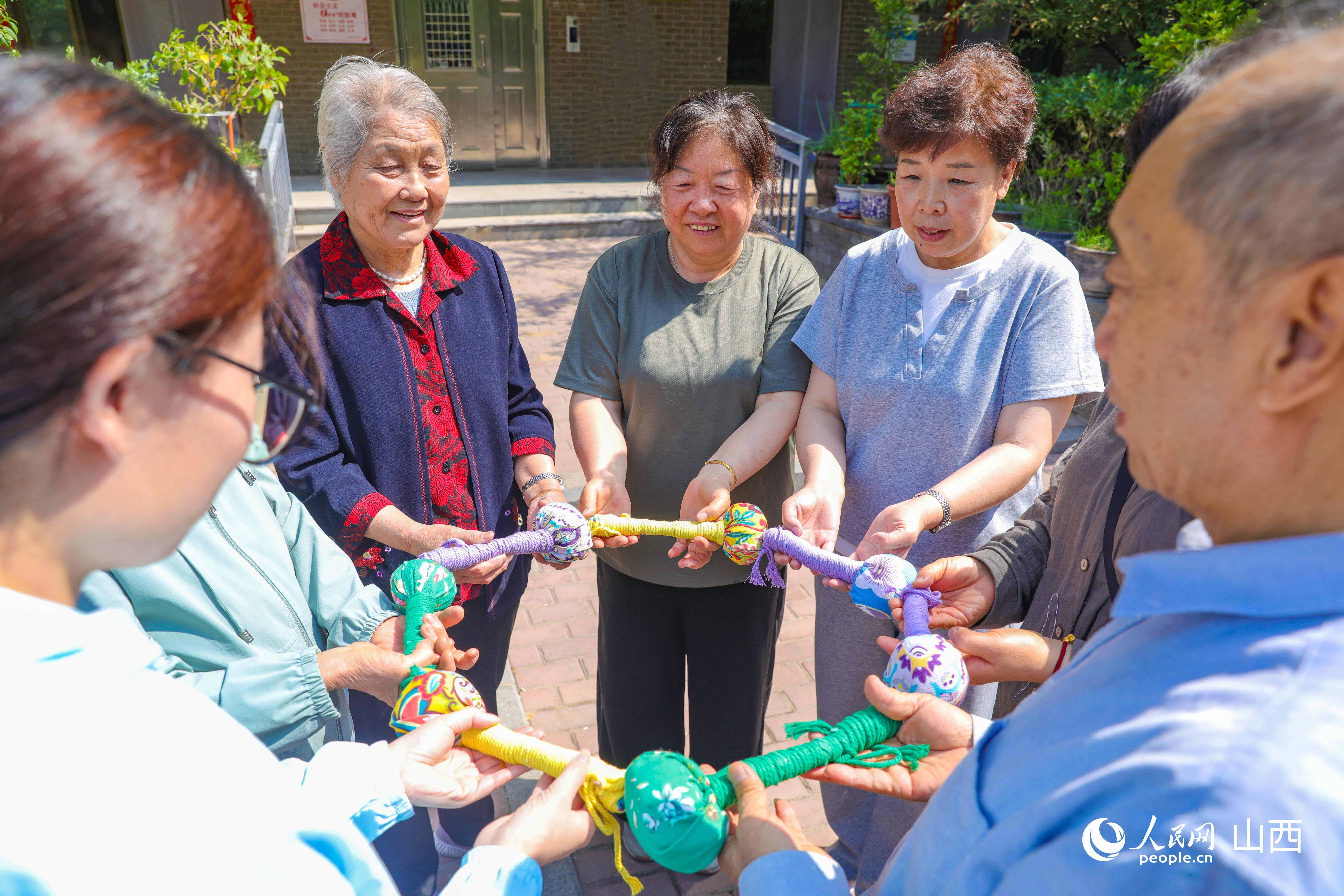 居民們展示五顏六色的棉麻拍打棒。