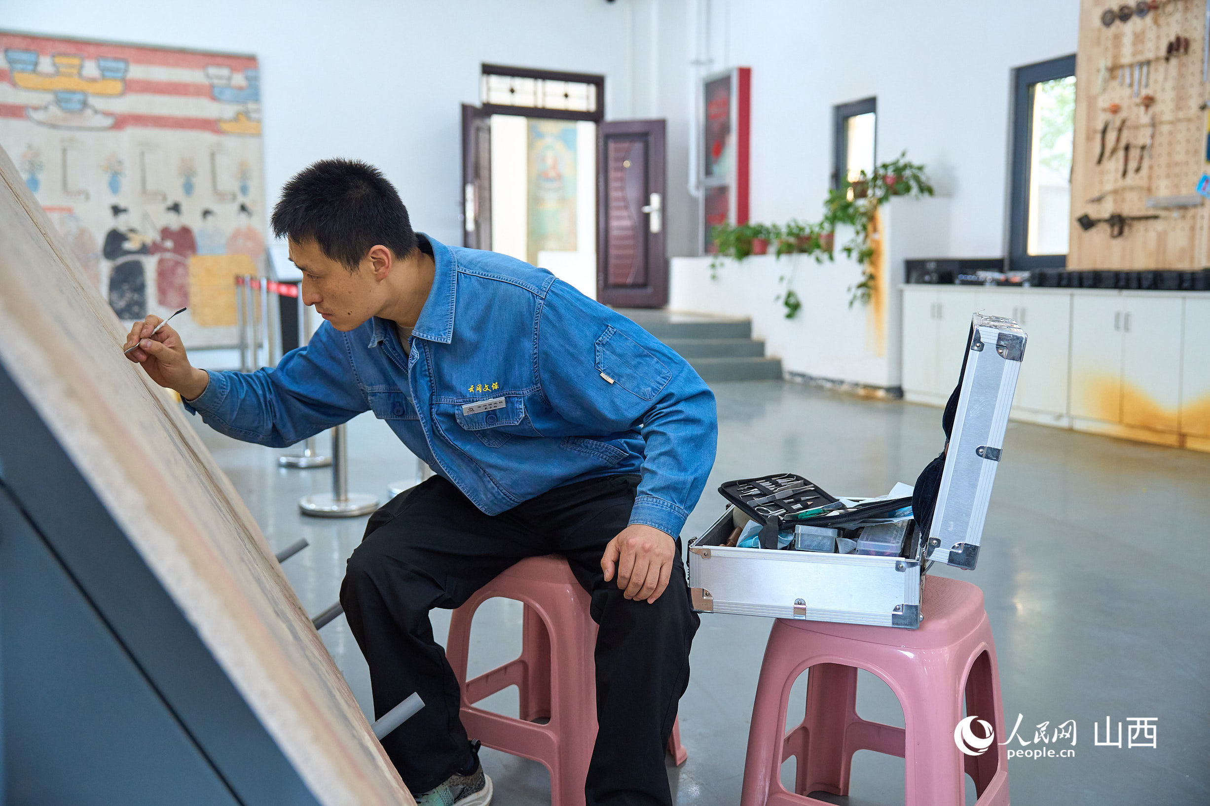 戴宇翔正在修復壁畫。人民網 張超寧攝