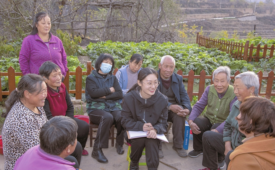 郭子涵（中）走訪農戶，聽取村民意見。通訊員攝
